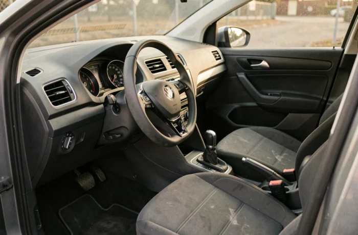 Interno della Volkswagen Polo 6R che mostra il cruscotto, il volante e i sedili in tessuto